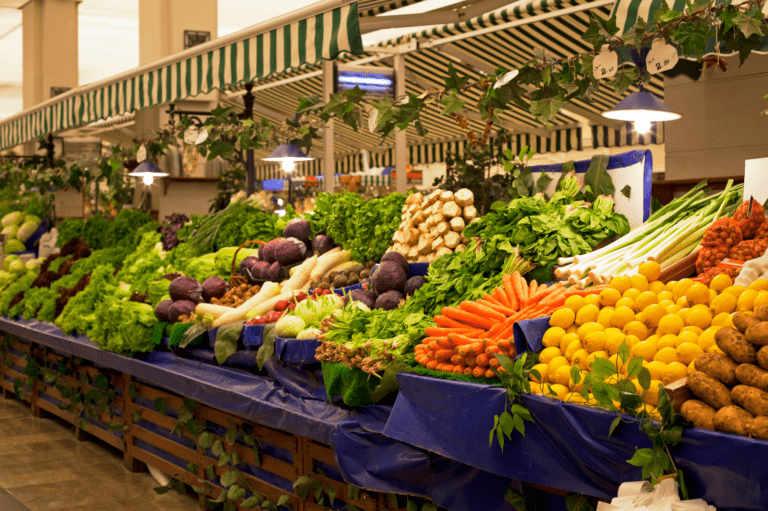 Fresh organic fruits and vegetables displayed in wooden displays at a market